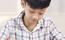 chinese boy does schoolwork or homework