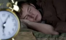 Teen_boy_snoozing_with_alarm_clock_iStock_8820264_LARGE.webp