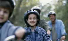 family riding bicycles through nature scene