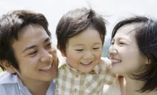 happy parents either side of toddler-age boy