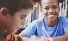 two boys doing schoolwork in the library