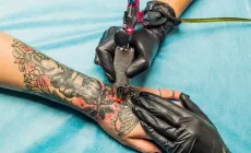 large tattoo being done on forearm